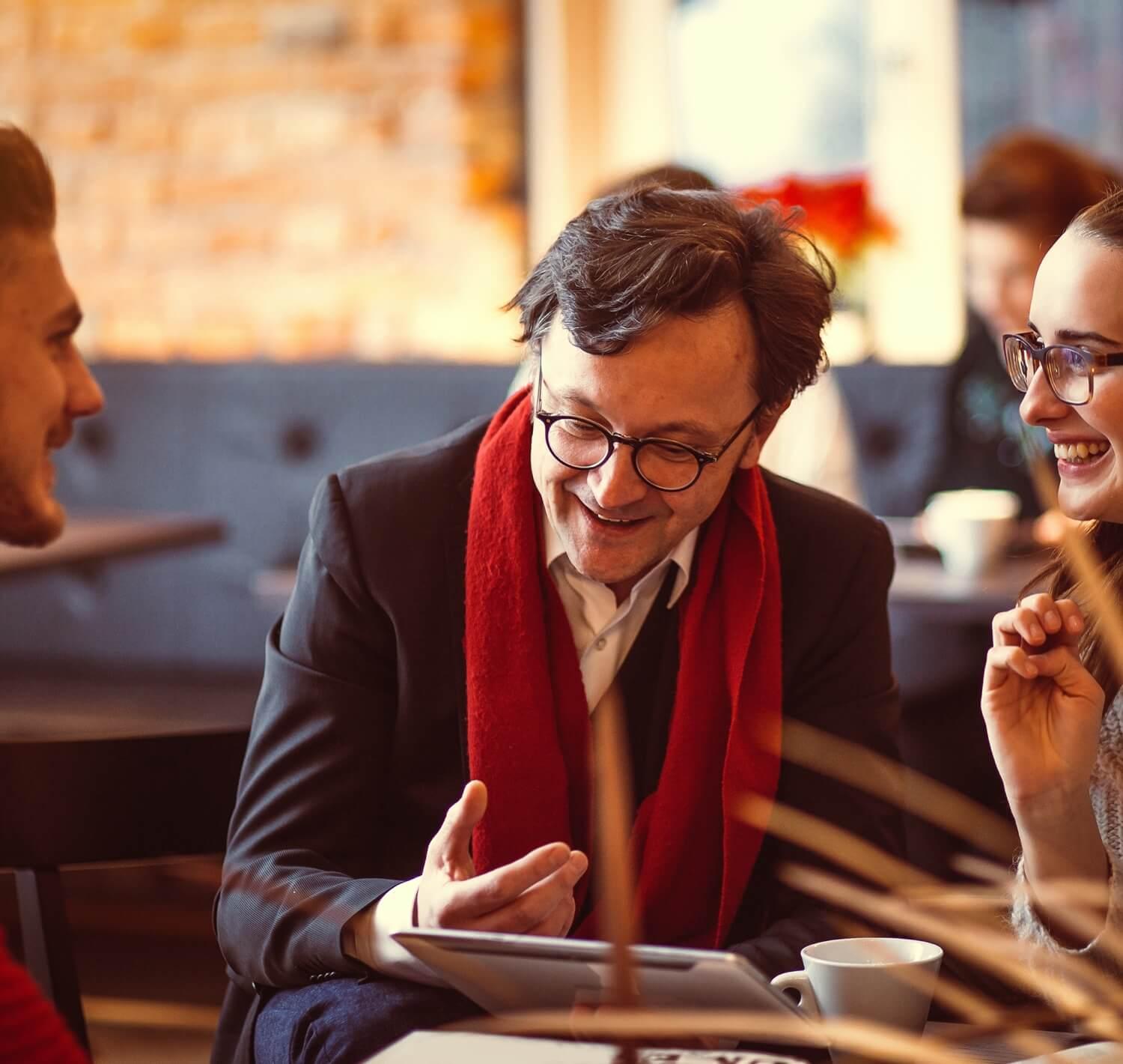 Professor talking to two people sitting at a table