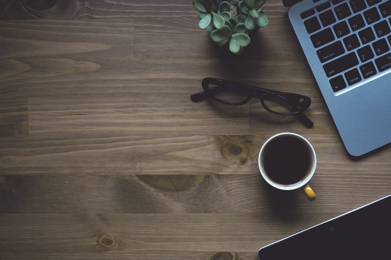 laptop and glasses on wooden desk